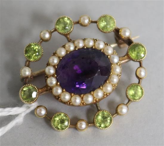 An Edwardian 15ct gold amethyst, peridot and pearl openwork brooch, in the suffragette colours, 28mm.